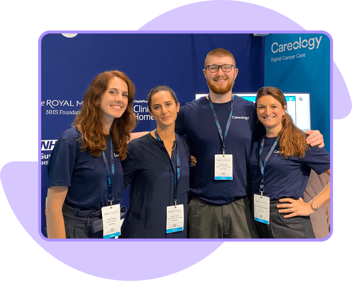 Four individuals in navy shirts standing in front of a Careology Digital Cancer Care booth.