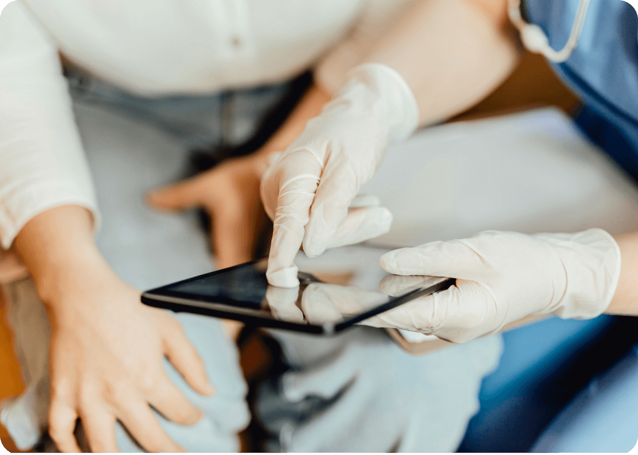 Pair of hands in medical gloves using a digital tablet