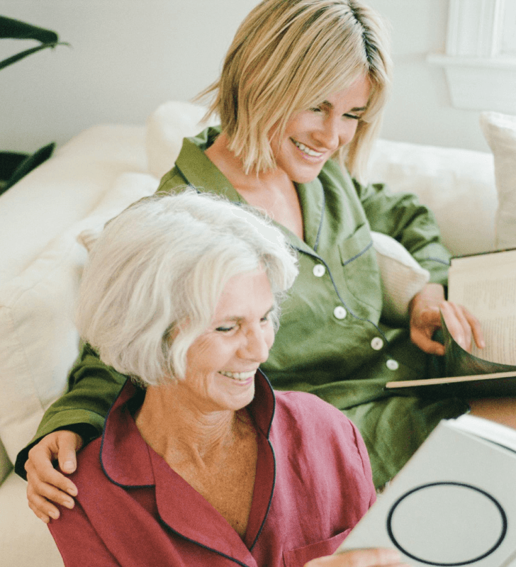 Two people, one in green and the other in red, sitting and reading books together.